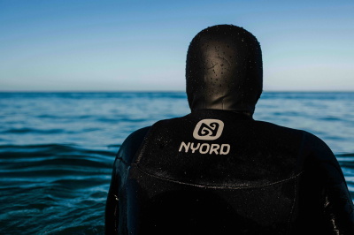 Surfista con una muta Nyord in spiaggia