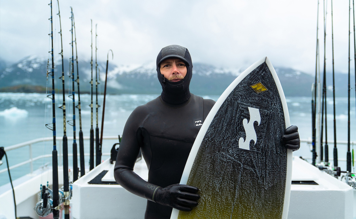Surfista con una muta Billabong realizzata con jersey, fodere e schiuma riciclati