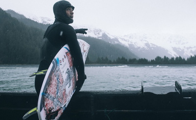Surfista con calzature, guanti e cappuccio