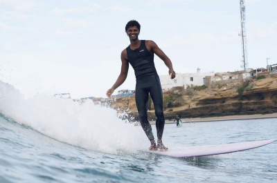 Surfista con la muta senza maniche Nyord Solu Long Jane in spiaggia d'estate